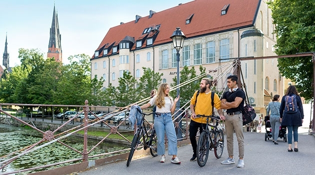 Tres estudiantes caminando junto a sus bicicletas en la ciudad de Uppsala, Suecia. Foto de Mikael Wallerstedt